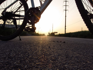 A bicycle parked on the road in the sunset