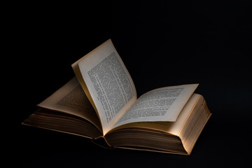 Obraz premium Geöffnetes Buch auf schwarzem Hintergrund