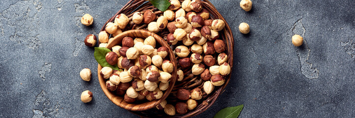 Hazelnuts and green leaves on gray background