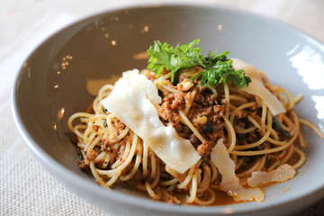 spaghetti Bolognese with minced beef and tomato sauce garnished with parmesan cheese and basil , Italian food