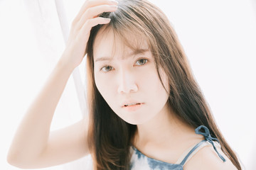 Fototapeta premium Portrait beautiful asian girl looking in white room film vintage style