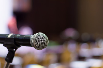 closeup microphone on stage with copy space in the hall for speaker and background.