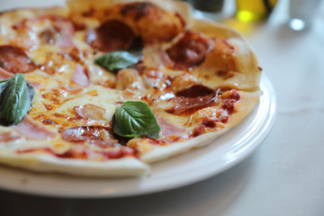 pepperoni bacon and ham pizza in restaurant background