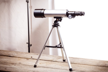telescope on a white background laid on wooden board