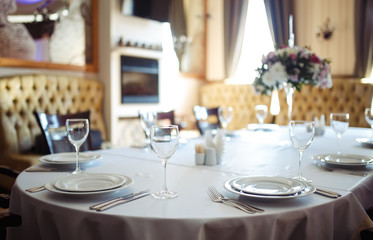 Sparkling glassware stands on long table prepared for wedding dinner.