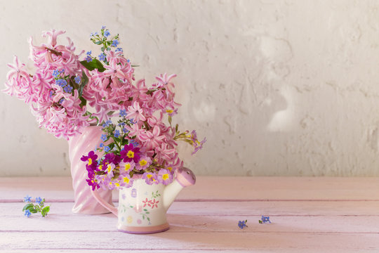 spring flowers in vases on wooden table