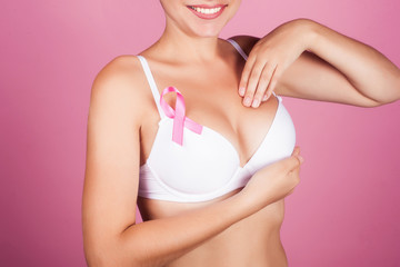 healthcare and medicine concept - woman with pink breast cancer awareness ribbon.