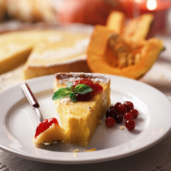 Pumpkin cake, cooked for the celebration of Halloween and decorated with cranberry and mint twig. Food photography