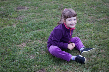 Fototapeta premium little girl fooling around on the green lawn