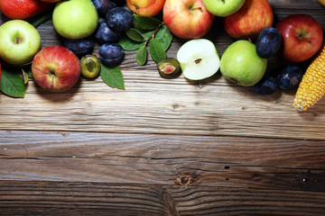Various fresh fruits. Thanksgiving pumpkin, apples, and maize on rustic background.