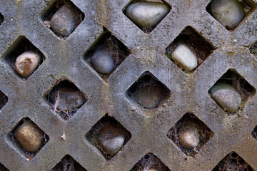 Stone wall with rocks in holes and spiderwebs - Garden