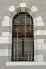 Fototapeta na wymiar antica finestra a volta con sbarre con ornamento Como, Italia