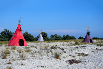 Three Indian wigwams lodge or teepee at the seashore at summer. travel concept. copyspace