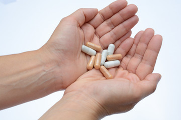 Manos mostrando un cóctel de diferentes medicamentos para el tratamiento de enfermedades como el VIH o simplemente como complementos alimenticios o adelgazamiento
