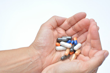 Manos mostrando un cóctel de diferentes medicamentos para el tratamiento de enfermedades como el VIH o simplemente como complementos alimenticios o adelgazamiento