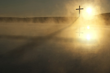 This Sunrise Cross on a misty lake casts a lengthy shadow and reflection on this calm Easter Morning Illustration - 218234719