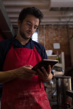 Male baker using digital tablet