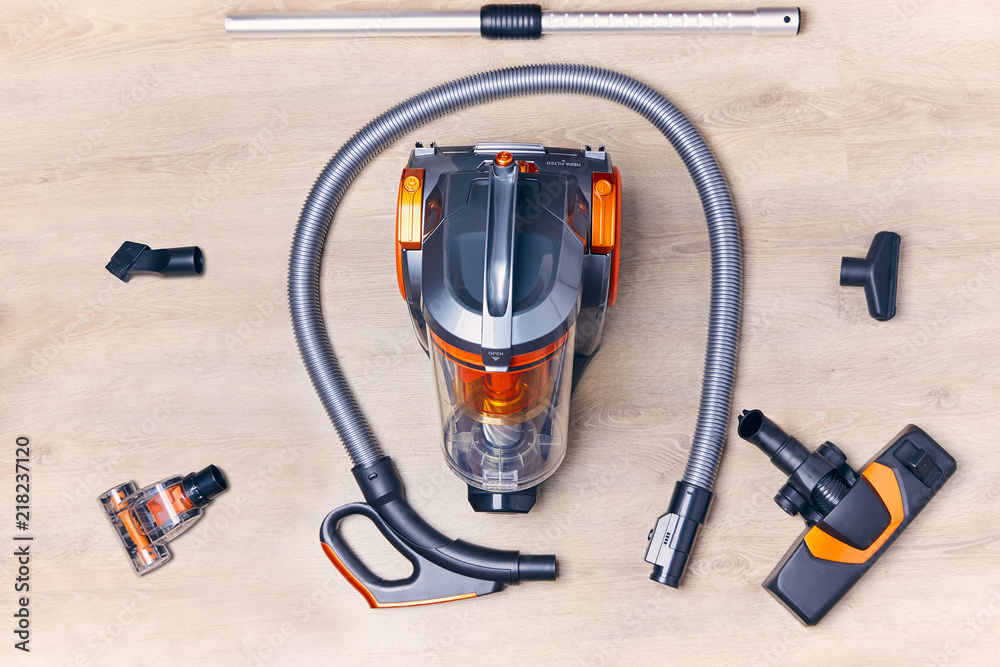 Wall mural top view of a modern vacuum cleaner with a container with nozzles and a hose spread out around it