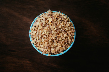 cup of brown rice on wooden table