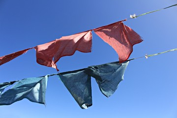 Old pale mantra flags from Bhutan and bright blue sky. This photo took from Thimpu, Bhutan in April 2015
