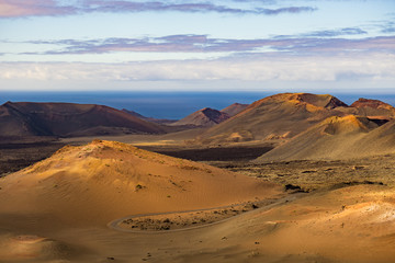 Desert scene with ocean background of Timanfaya National Park
