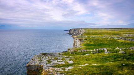 Beautiful view of the Inis Mór cliffs on a cloudy day. Taken from the top of the high cliff edge, showing the fields and ocean on a calm day. © Michaella