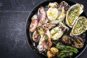 Traditionelle gegrillte Meeresfrüchte Platte mit  Gemüse als Draufsicht auf einem Teller mit Textfreiraum links  © HLPhoto