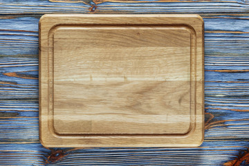 Chopping board on vintage wooden background