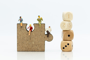 Fototapeta premium Miniature people : businessman sitting on jigsaw puzzle pieces . Image use for solve, finding solution, business vision concept.