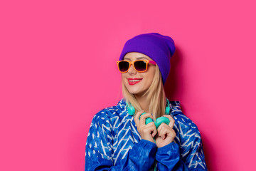 young blonde girl in 80s style clothes on pink background