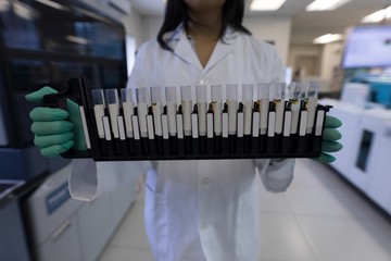 Laboratory technician holding test tubes