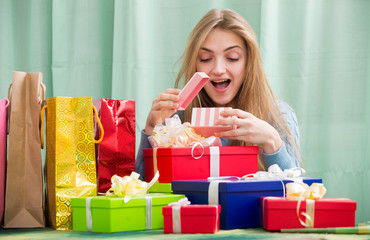 Cheerful girl opening box with gift