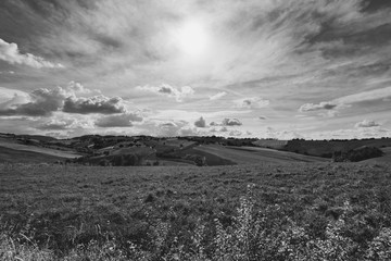Black and white countryside landscape , sky with clouds and fields at summer