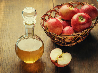 Apple cider vinegar and basket with red apples