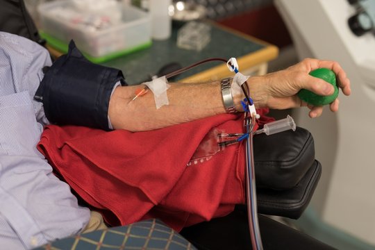 Senior man donating blood in blood bank
