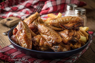 Baked chicken wings with french fries.
