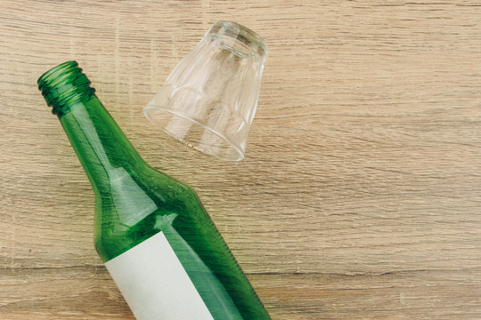 top view of soju bottle with glass on the wooden table. Soju is the colorless distilled beverage, the most popular liquor in Korea