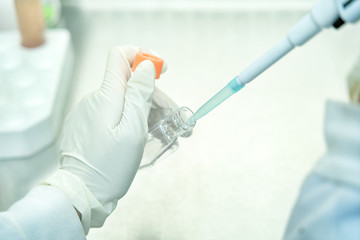 The woman changing the a new growth medium for culture medium into the flask for maintain cell line...