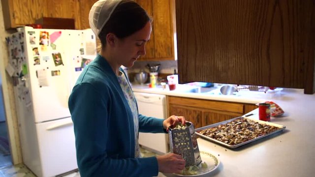 A Mennonite woman prepares food in her country home in slow motion.