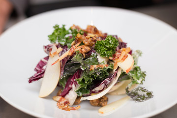Healthy kale salad with pancetta, apple, and nuts.