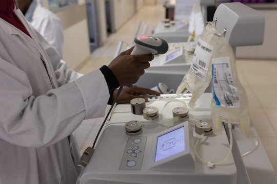Laboratory technician scanning bar code of plasma bags