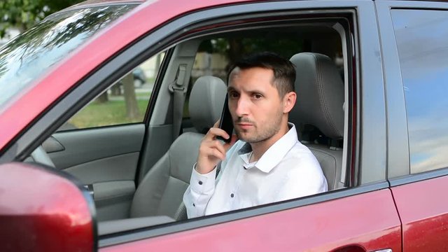 Young driver being impatient, waiting inside his car and showing signs of frustration.
