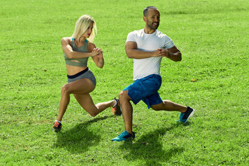 Sports multinational family; wife and husband doing sport exercises together outdoor