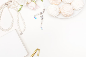 Beauty blog background. Gold style feminine accessories. Golden tinsel, scissors, pen, rings, necklace, bracelet , flowers and sweety on light background. Flat lay, top view