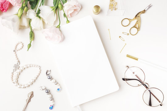 Beauty blog background. Gold style feminine accessories. Golden tinsel, scissors, pen, rings, necklace, bracelet , flowers and sweety on light background. Flat lay, top view