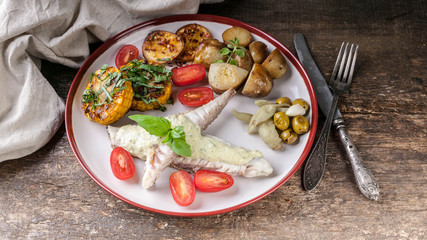Fillet of sea fish with cheese sauce with baked vegetables