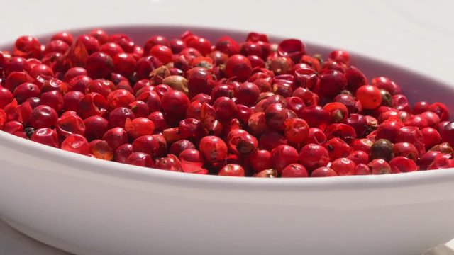 Dry spices pink pepper on a rotary table. 4K. Macroshooting.