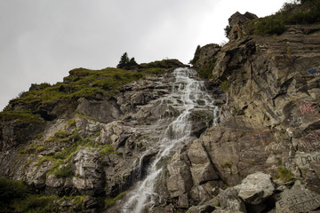 Fototapeta na wymiar Small waterfall in Romania Carpathians Transfagarasanu pass or road