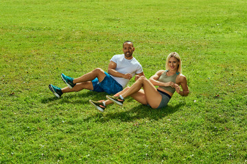 Sports multinational family; wife and husband doing sport exercises together outdoor