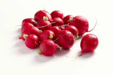 Group of fresh red radishes on white surface